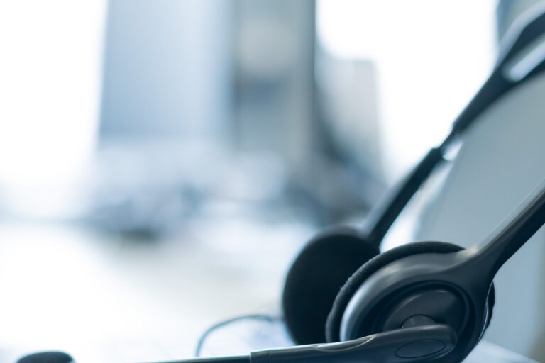 Nahaufnahme eines Headsets auf einem Laptop. Helpdesk. Arbeitsplatz eines Support-Service-Mitarbeiters.