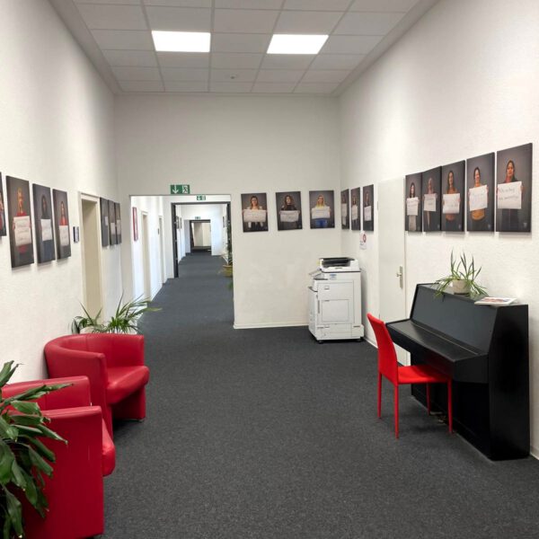 Foto der German Language Academy am Bahnhof. Zu sehen ist der Wartebereich. Hier steht ein Klavier und es hängen viele Bilder an den Wänden.