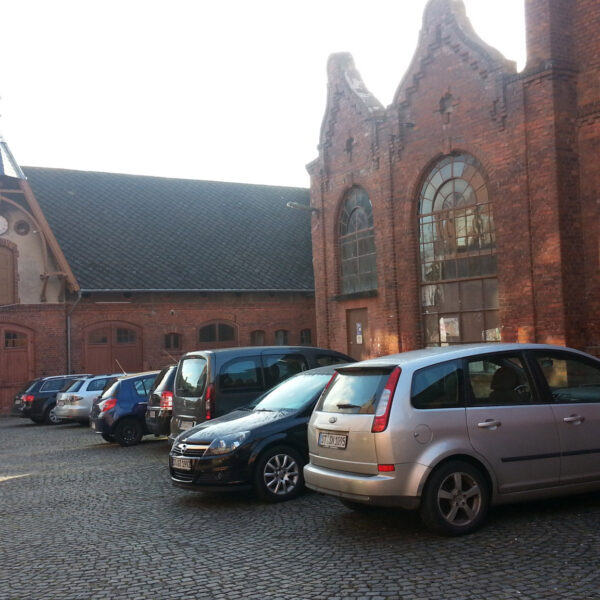 Foto vom Gebäude am Standort in Steinfurt. Zu sehen ist das alte Fabrikgebäude und die Parkplätze.