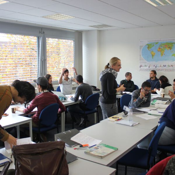 Foto der German Language Academy am Bahnhof. Zu sehen ist eine Lernsituation mit Personen.